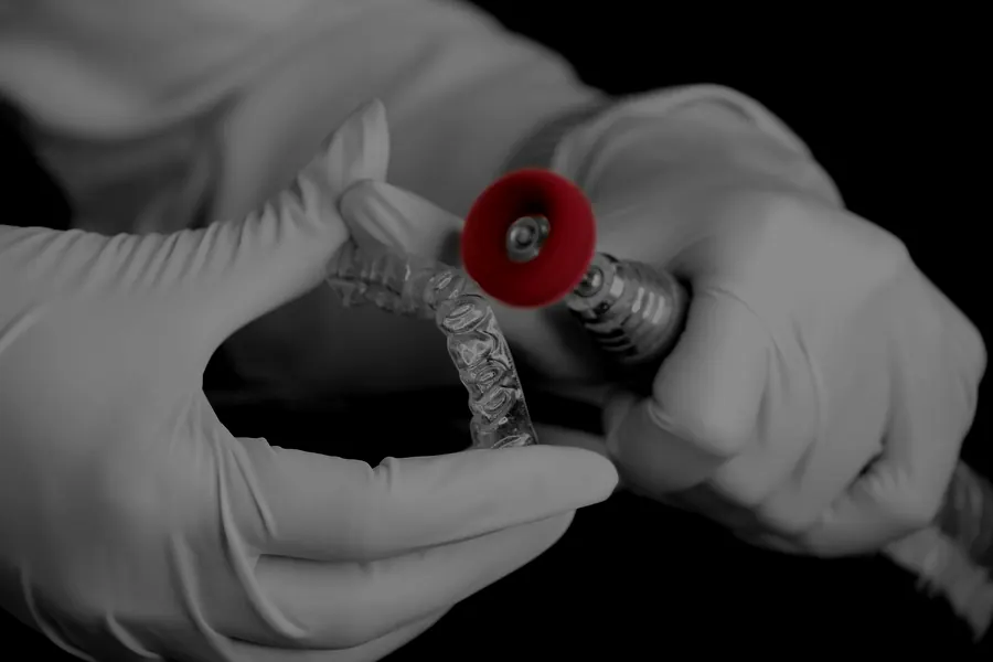 A technician polishing a clear aligner tray by hand in our laboratory