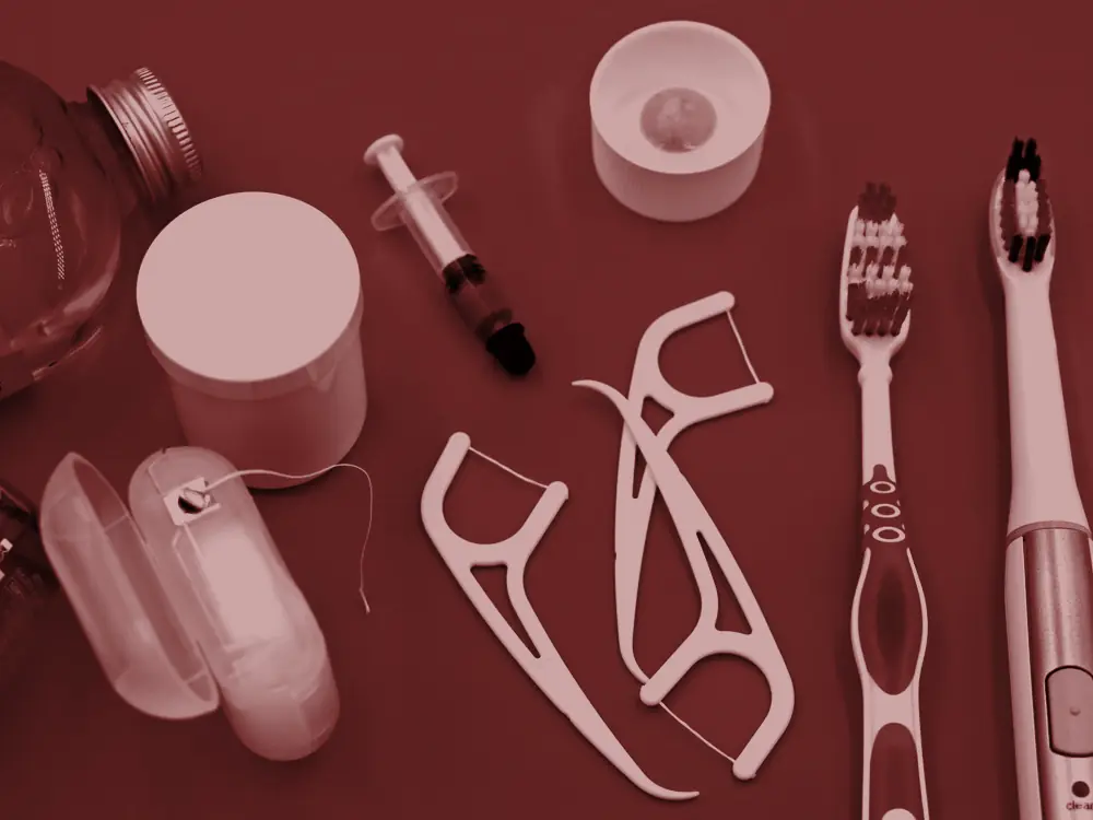 Floss, toothbrushes and dental hygiene products on a blue background