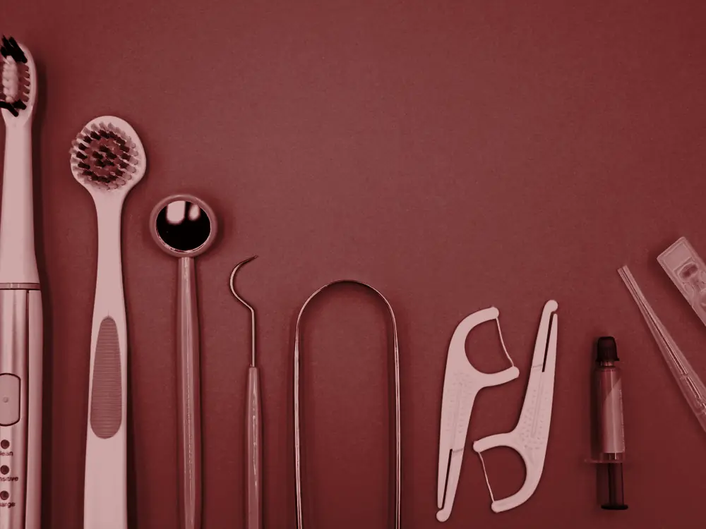 Toothbrush, floss picks and dental tools on a blue background