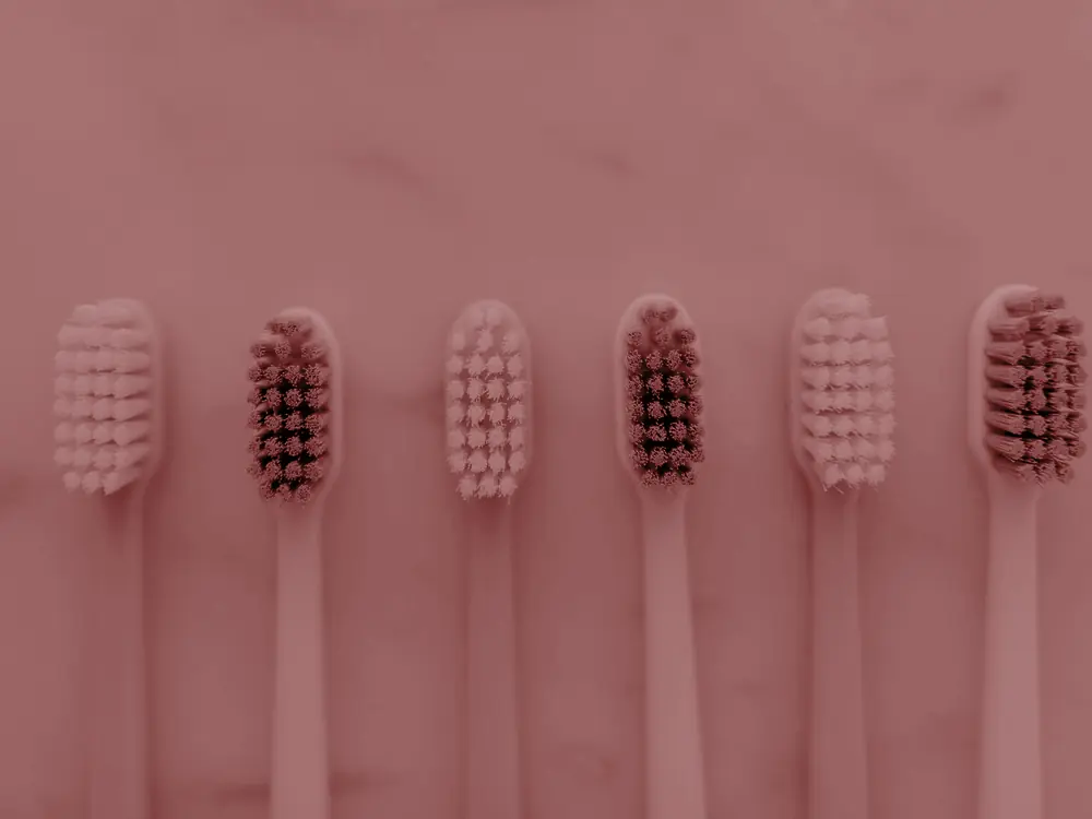 Row of toothbrushes on a marble surface